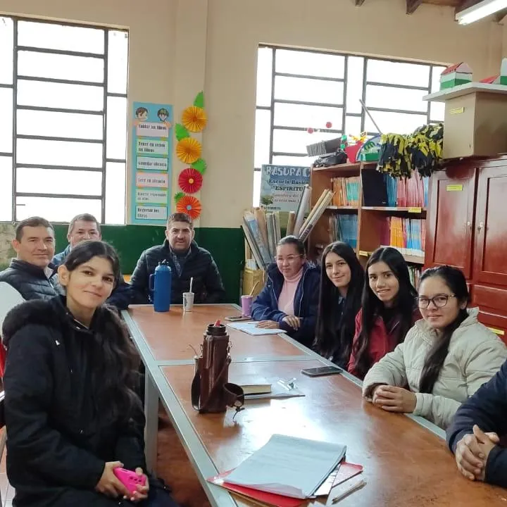 Estudiantes reunidas alrededor de una mesa en el aula
